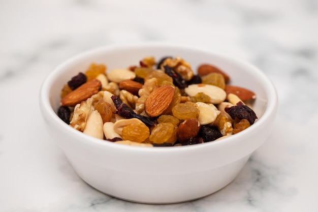 Dry fruits in white small bowl on light gray