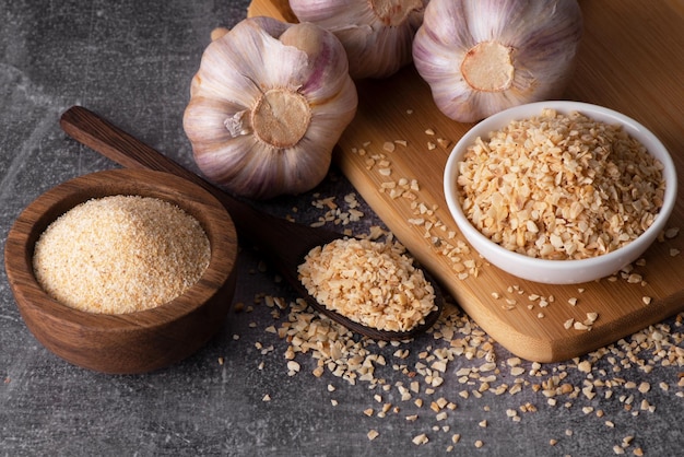 Dry garlic granules. Spice garlic. Dry garlic powder in a wooden bowl and spoon.