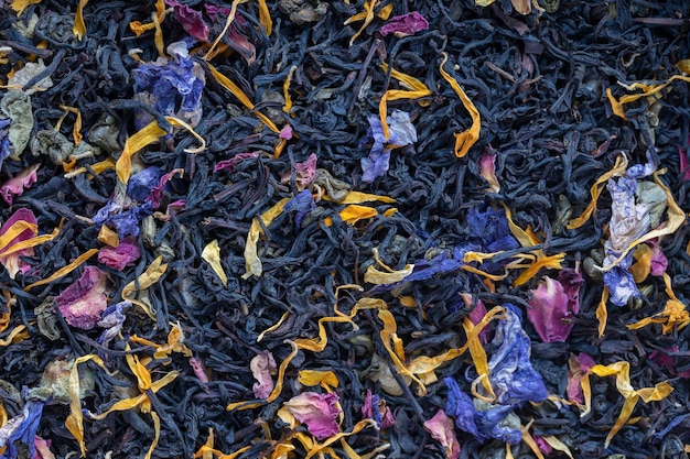 Dry herbs tea with fruit and flower petals as background top view Healthy eating concept