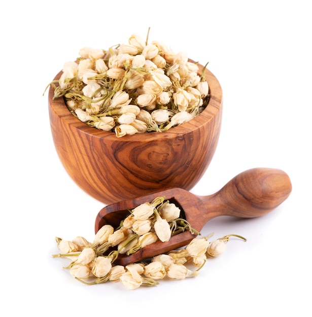 Dry jasmine flowers in wooden bowl and spoon isolated on white background Jasmine flowers tea Herbal tea