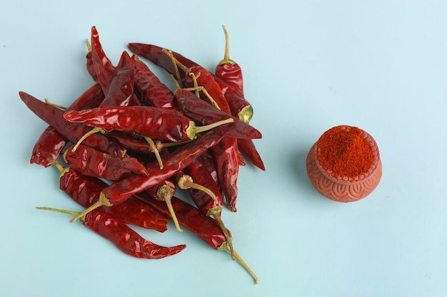 Dry red chilly and powder on white background.