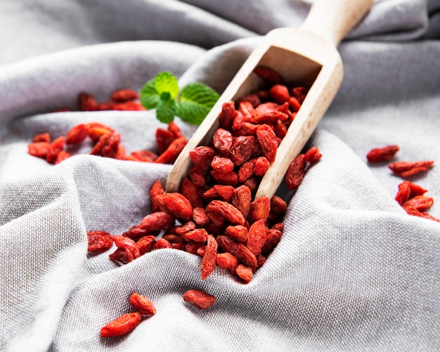 Dry red goji berries for a healthy diet on a fabric background