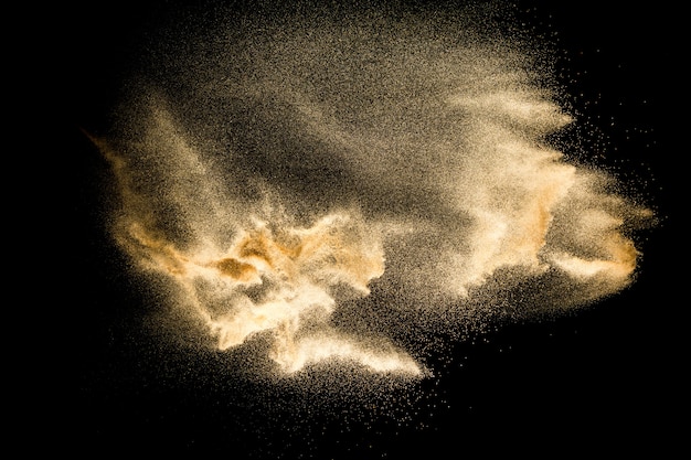 Dry river sand explosion isolated on black background. Abstract sand cloud.Brown colored sand splash against dark background.