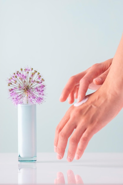 Dry skin of hands rubbing white cosmetic cream on goleb background