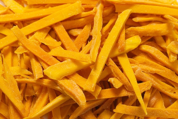 Dry tasty mango slices as a background. Top view.