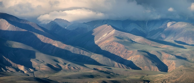 Dry treeless mountain slopes in the south of Altai, storm clouds