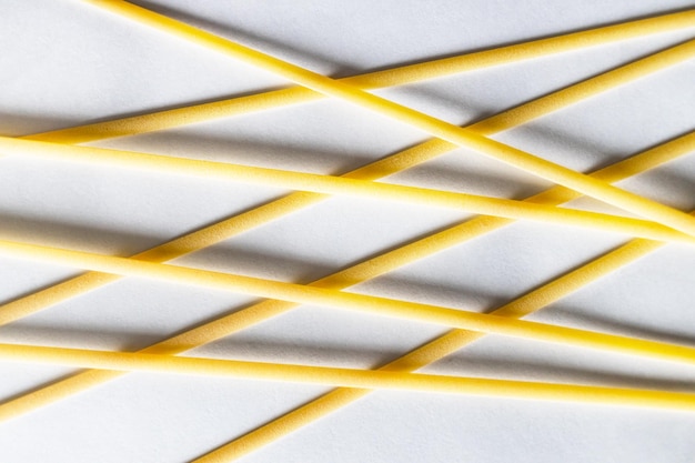 Dry uncooked linguine pasta on white paper closeup