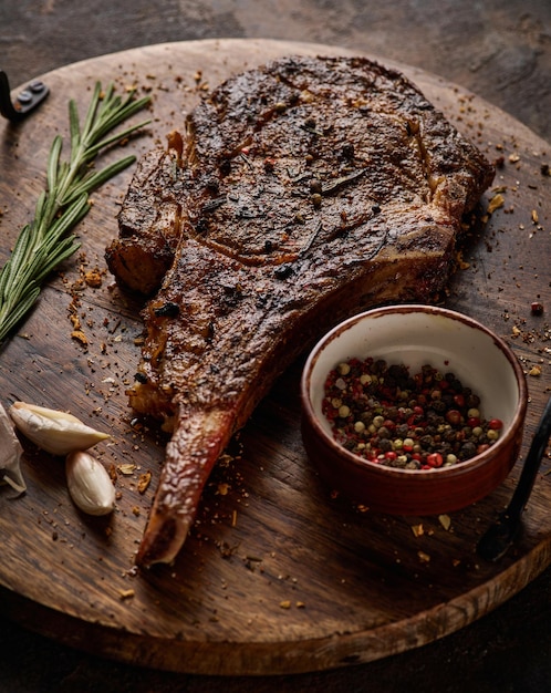 Dryaged marble beef steak Tomahawk on wooden board with spices Closeup Juicy delicious ribeye or tomahawk steak