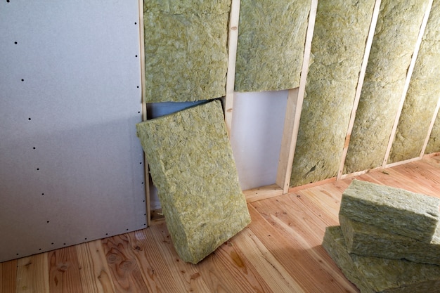 Photo drywall plates insulated with rock wool and fiberglass insulation staff for cold barrier.