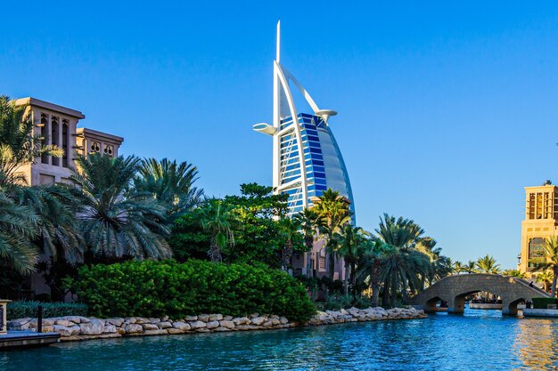 Photo dubai, uae - 10 october 2017: view for burj al arab hotel from the madinat jumeirah in dubai, uae. burj al arab with 321 meters high is the most luxurious 7 star hotel and a symbol of modern dubai.