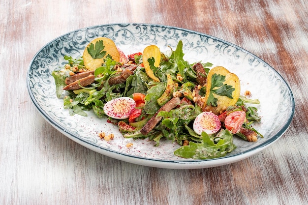 Duck breast salad with potato chips and fresh vegetables On a decorative plate