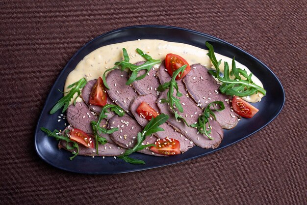 Duck breast with arugula cherry tomatoes and sesame seeds on a creamy sauce