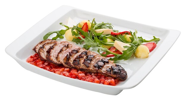 Duck breast with arugula and strawberry chutney on white background