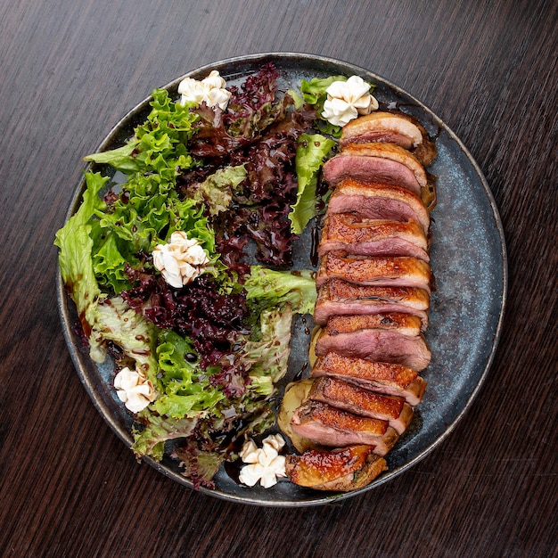 Duck breast with lettuce and cream cheese On a wooden background