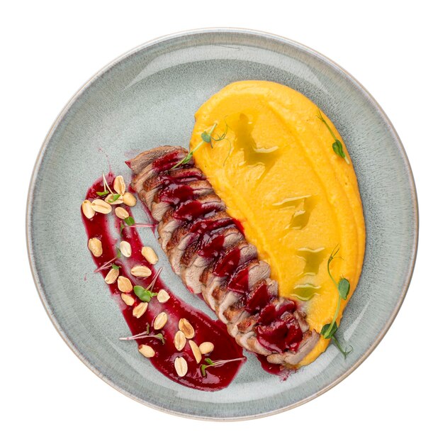 Duck breast with pumpkin puree cherry sauce and peanuts Isolated image