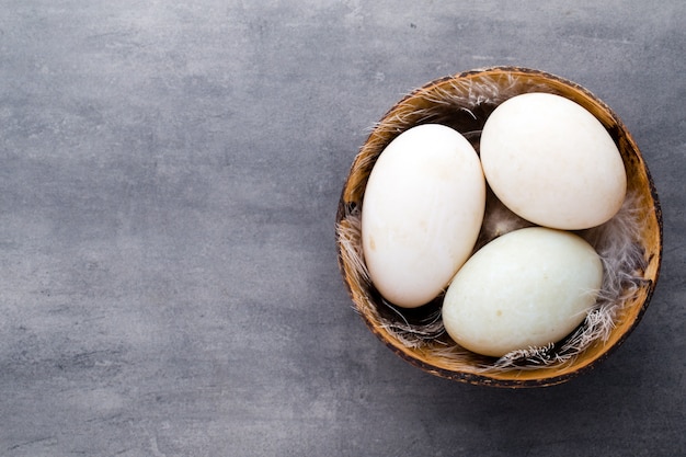 Duck eggs on a cage gray background.