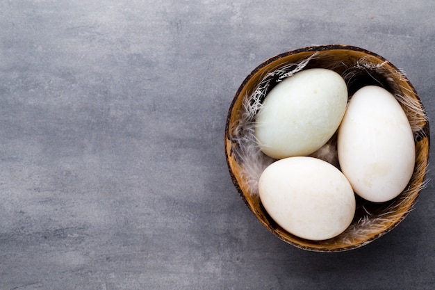 Duck eggs on a cage gray background.