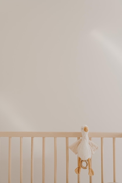 Photo duck toy in baby crib against white wall