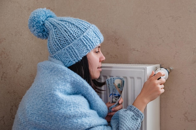 Due to the increase in the cost of heating the woman is dressed warmly and sets the thermostat to a minimum