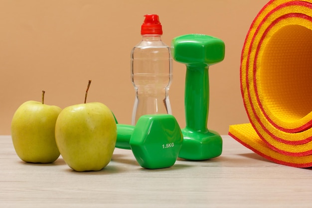 Dumbbells and different tools for fitness on floor in room