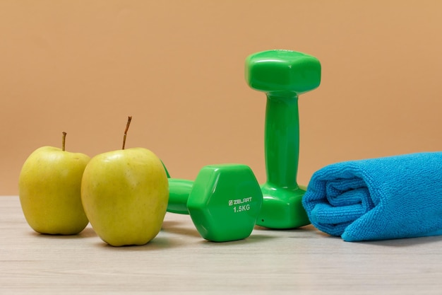 Dumbbells and different tools for fitness on floor in room