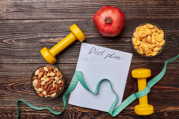 Dumbbells and measuring tape Bowls with nuts and cornflakes Strong healthy and happy