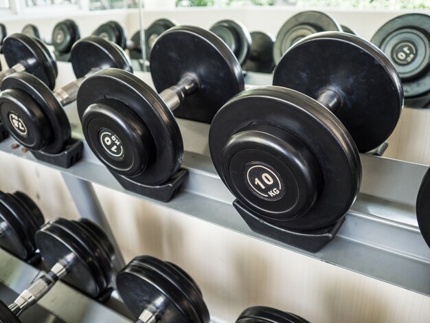 Dumbells set left on the racks in the gym.