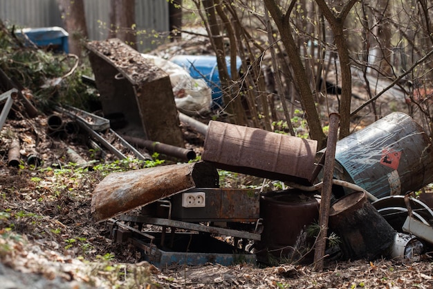 Dumping rusty dirty waste in the forest environmental hazard