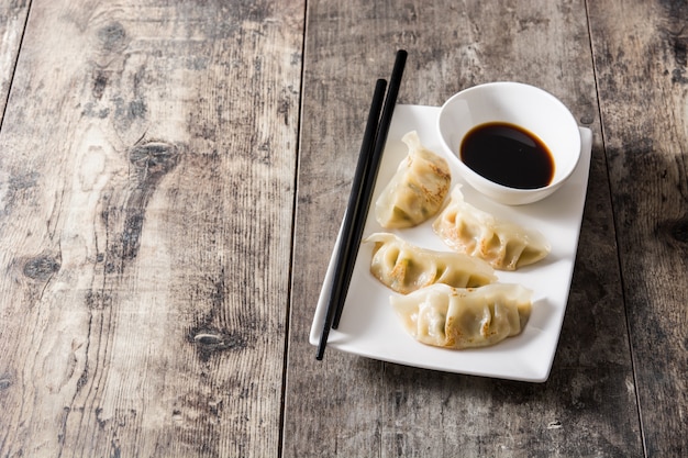 Dumplings and soy sauce on wooden table