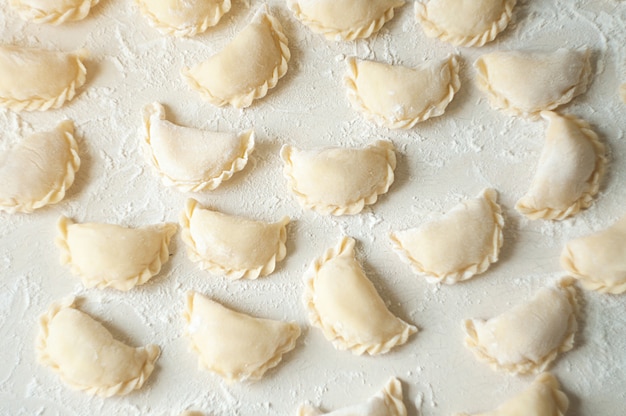 Dumplings (vareniki) with potatoes - traditional Ukrainian food. Cooking raw dumplings with potatoes