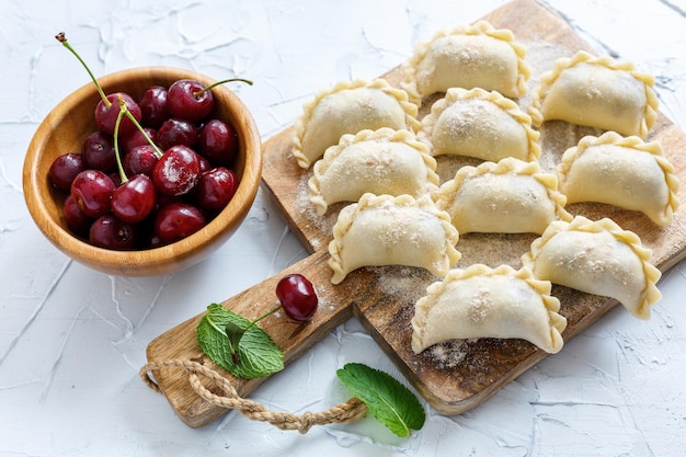 Dumplings with cherries on a wooden board