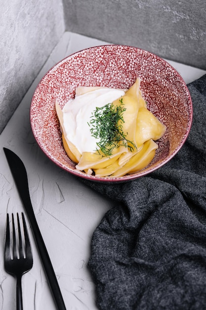 Dumplings with cottage cheese with sour cream on a plate