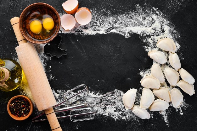 Dumplings with potatoes Vareniki Homemade Flour eggs dough on a black background Top view Free copy space