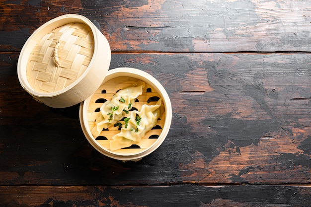 Dumplings in wooden steamer on wood background