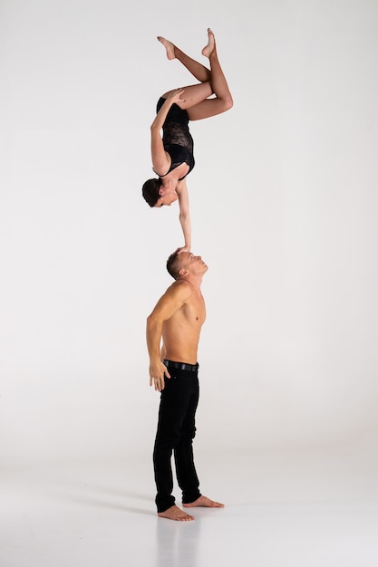 Duo Of male and female Acrobats Showing hand to hand Trick, Isolated On White