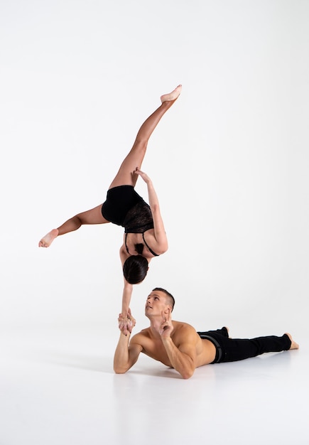 Duo Of male and female Acrobats Showing hand to hand Trick, Isolated On White