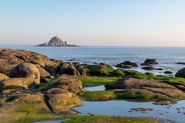 At dusk, the reef on the beach is covered with green algae, and the color is very beautiful