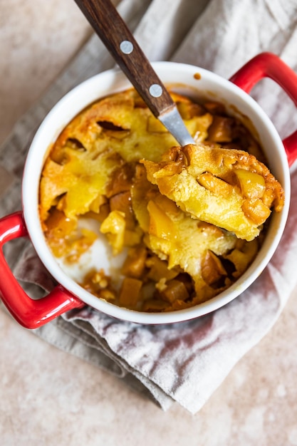 Dutch baby pancake with apples and honey in ceramic baking dish Delicious sweet breakfast