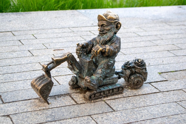 Dwarf gnomes sculpture with magnifying glass in downtown of famous polish city. Wroclaw Houses and s