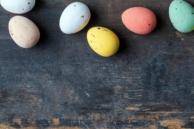 Dyed colorful easter eggs on a vintage wooden background texture, soft pastels modern design