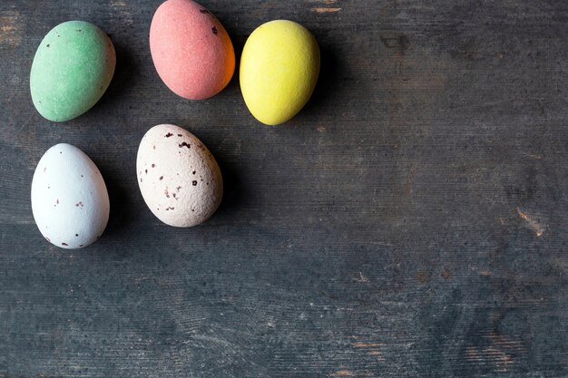 Dyed colorful easter eggs on a vintage wooden background texture, soft pastels modern design