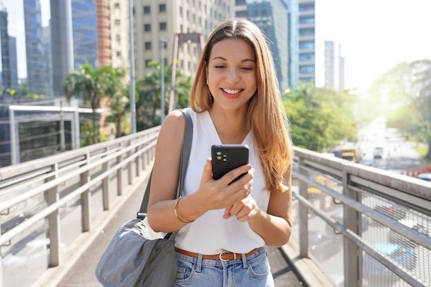 Dynamic Brazilian entrepreneur walking in Sao Paulo downtown using a mobile phone