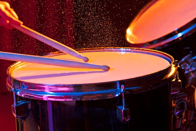 Dynamic scene. man playing the snare drum on a colored background, the concept of musical instrument