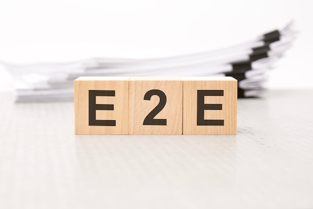 E2E letters on wooden cubes the background is a white business papers finance concept