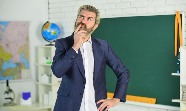 Each School defines final examination sessions Modern teacher lesson Study and education Modern school Knowledge day Handsome bearded man in classroom chalkboard Modern teaching method