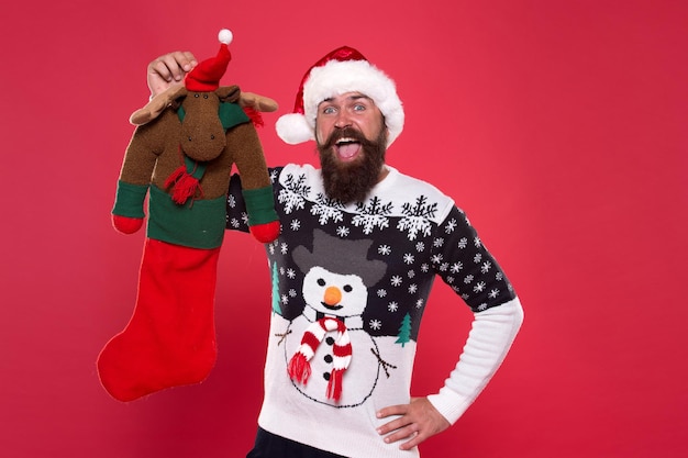 Each surprise is just that. Surprised hipster hold reindeer toy. Bearded man prepare surprise gift. Christmas Santa surprise. Merry xmas. Happy new year. Boxing day. Let Santa surprise you.