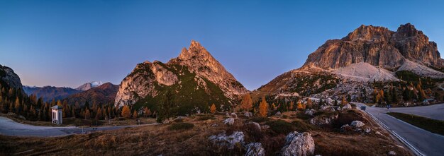 Early morning autumn alpine Dolomites mountain scene Peaceful Falzarego Pass view Belluno Italy Snowy Marmolada massif and Glacier in far