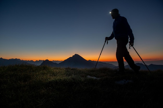 Early morning hiker walking with flashlight on head