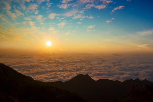 An early morning landscape with the sea of clouds below and the morning sun rising.