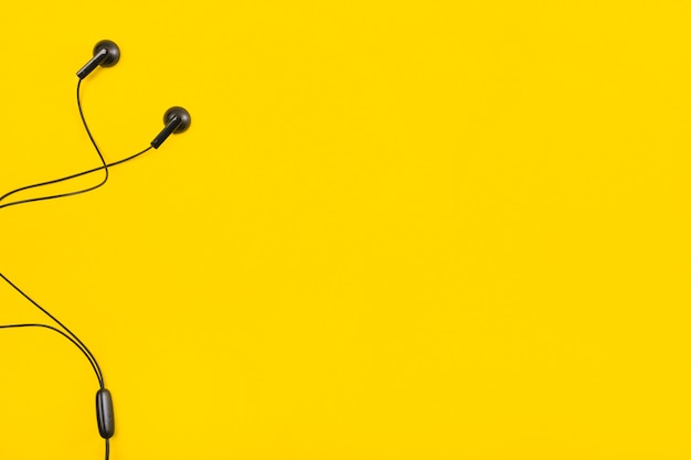 Earphone on yellow background with space for text